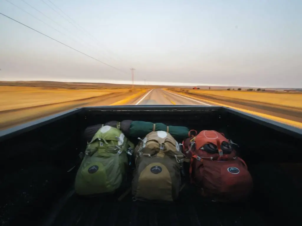 three hiking bags in a truck