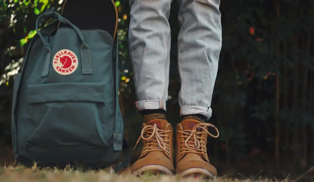 regular backpack next to hiking boots