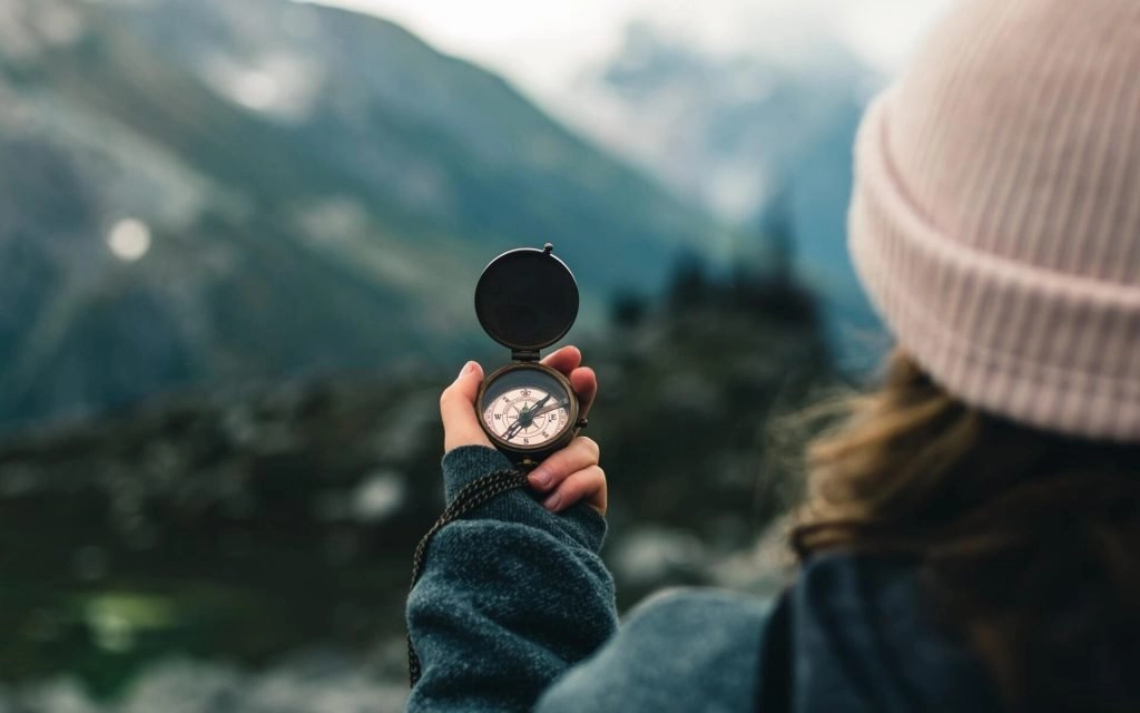 hiker staring at compass in forest