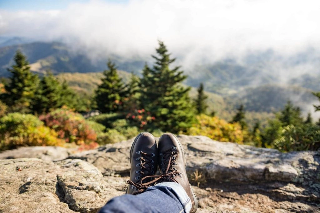 hiker sitting down with legs streched out on mountain