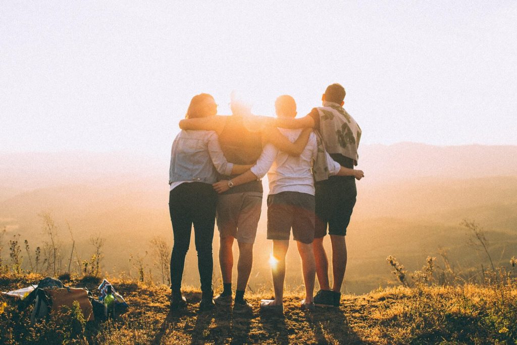 hikers staidning grouped together during sunset