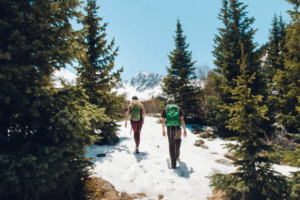 two hikers on snow in the mountains