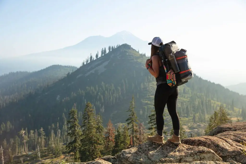 female hiker with pack staring at mountains