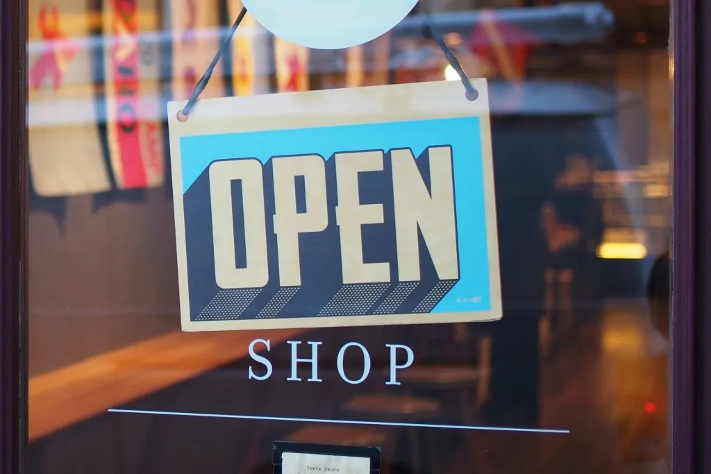 blue open shop sign on glass door