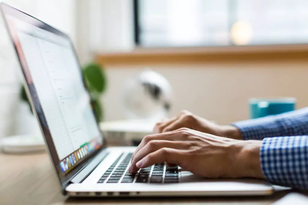 persons hand on open laptop keyboard