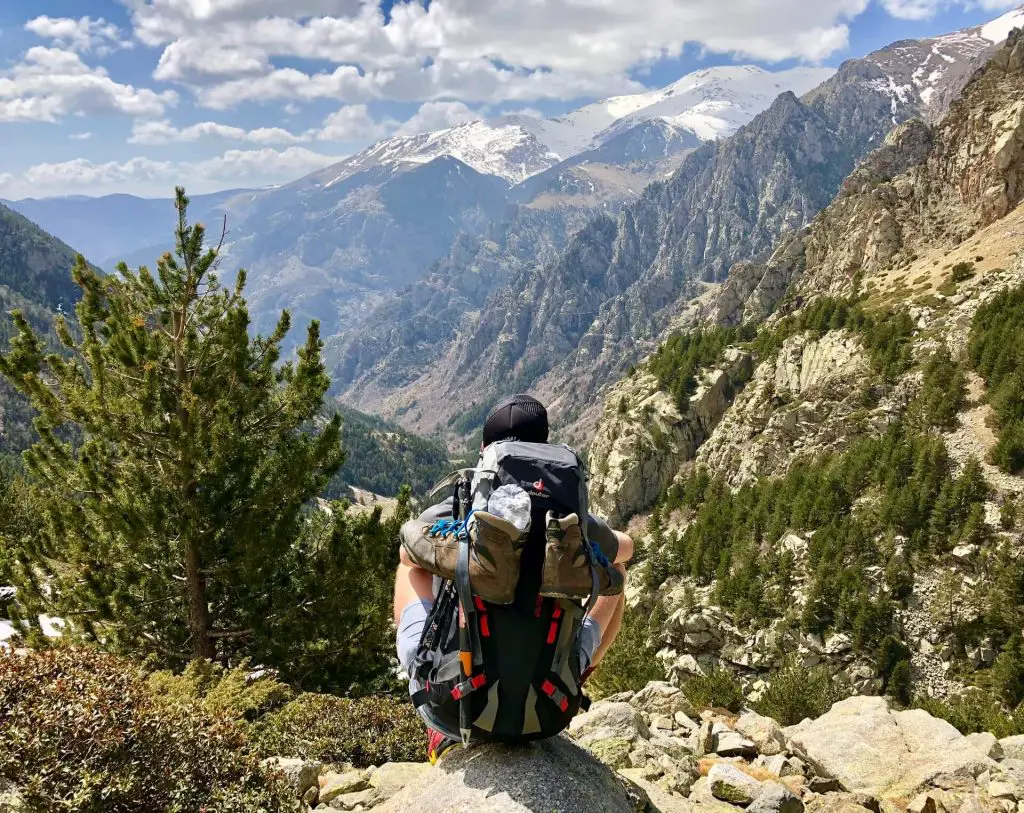 hiker sitting down with pack in the wilderness
