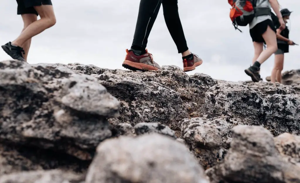 photo of hikers boots walking on rocks