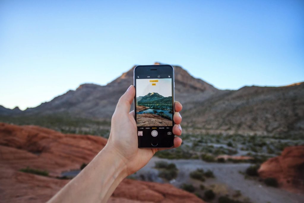 person holding phone in desert
