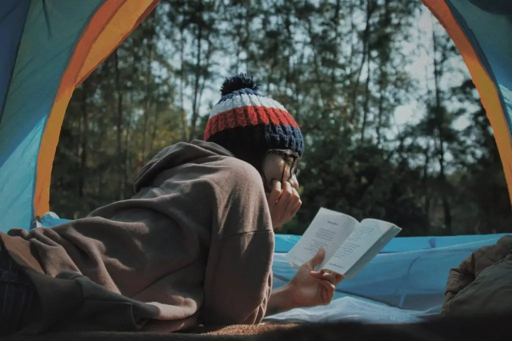 person reading inside tent