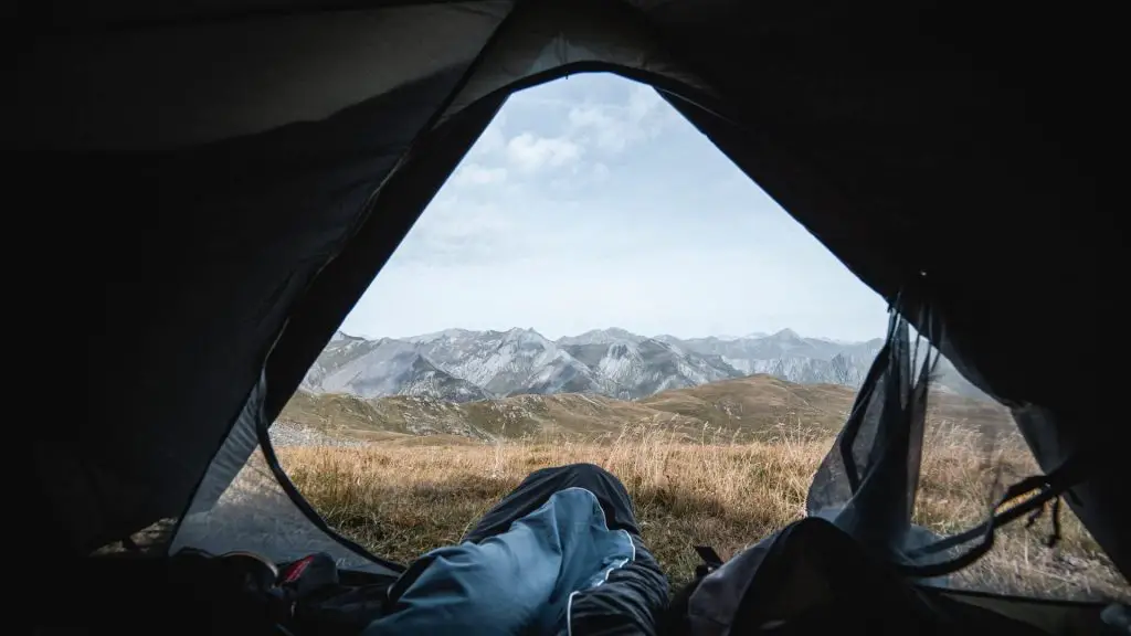 tent with door open and feet in sleeping bag