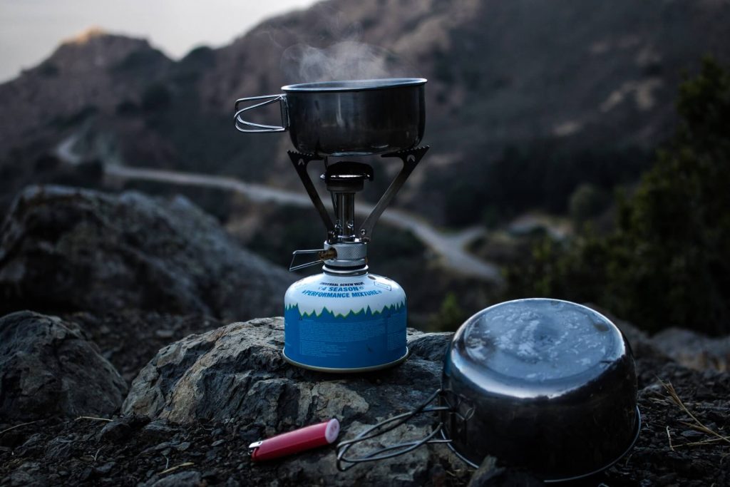 portable camping stove on rocks