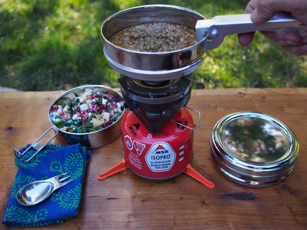 cooking a camping meal on a portable stove