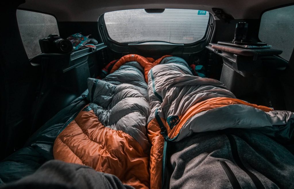 two sleeping bags rolled out in a car