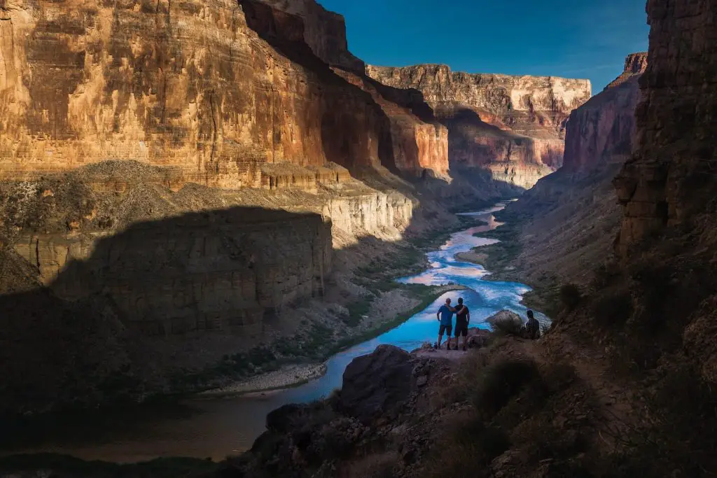 two hikers by colorado river in grand canyon