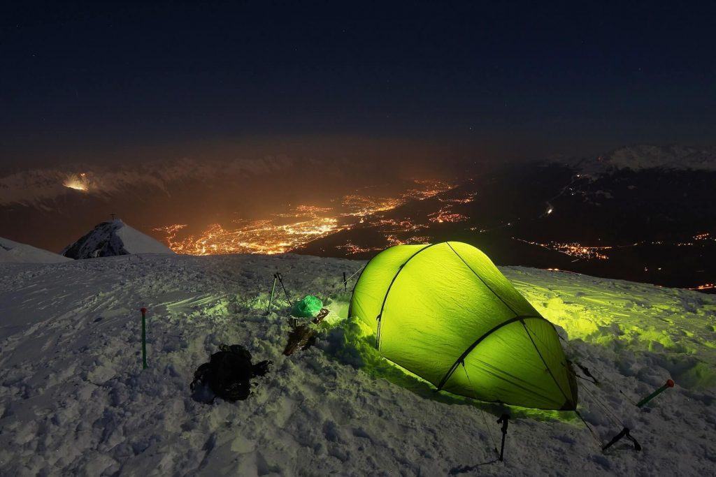 green tent in the snow at night