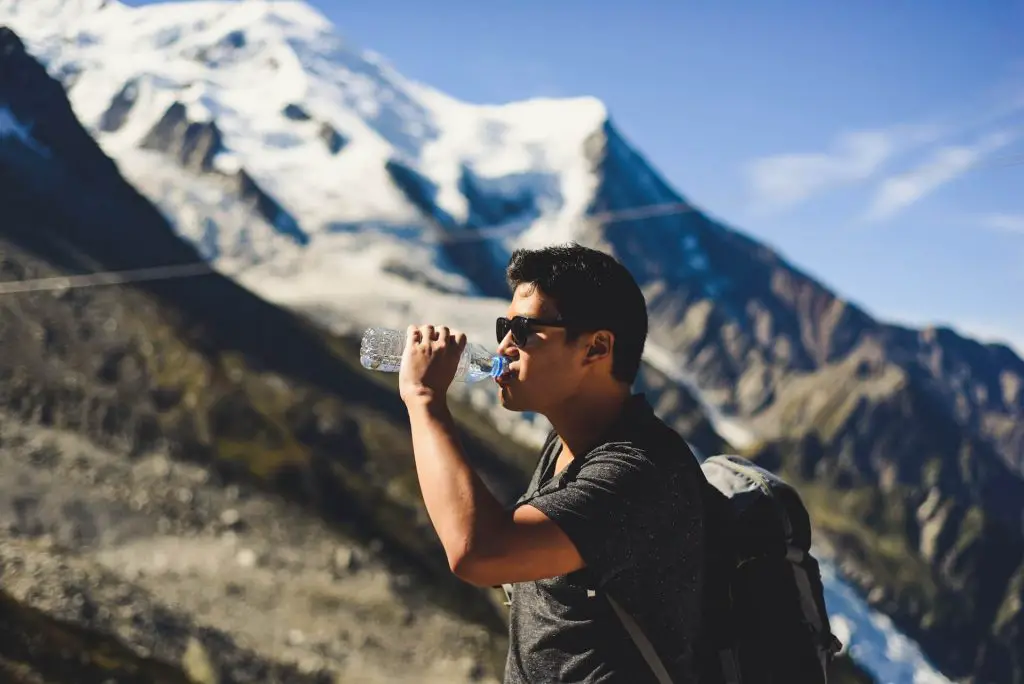 hiker drinking water on the trail