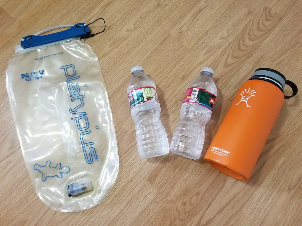 hydration bladder and insulated bottle on floor