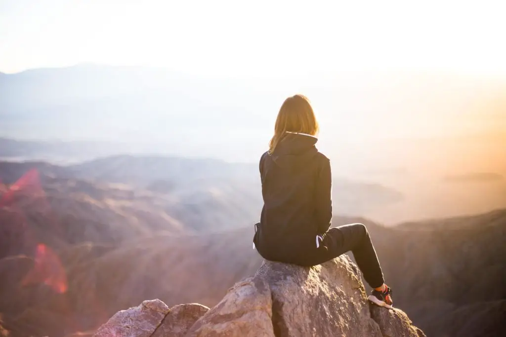 female hiker sitting down on rocks