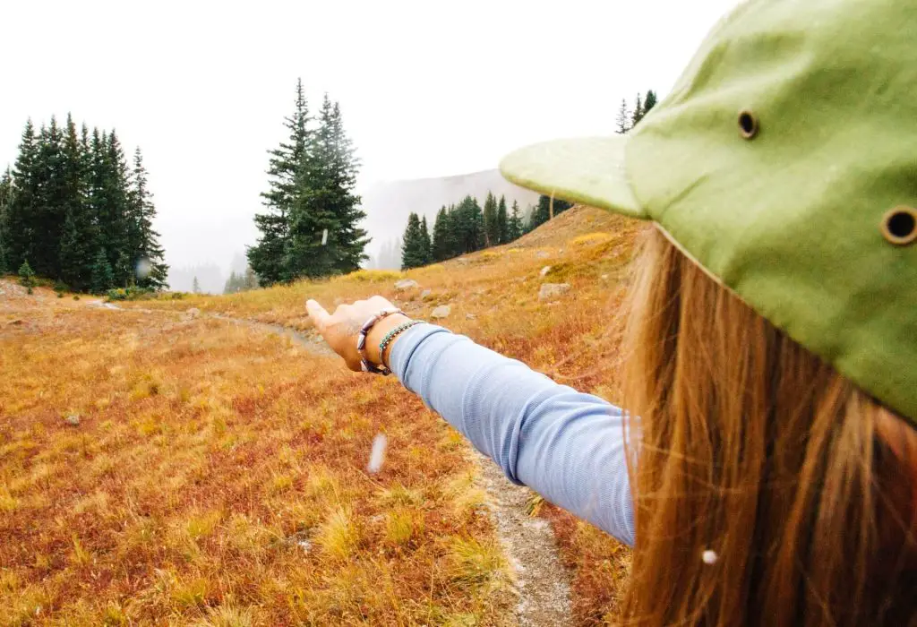 female hiker pointing to tree