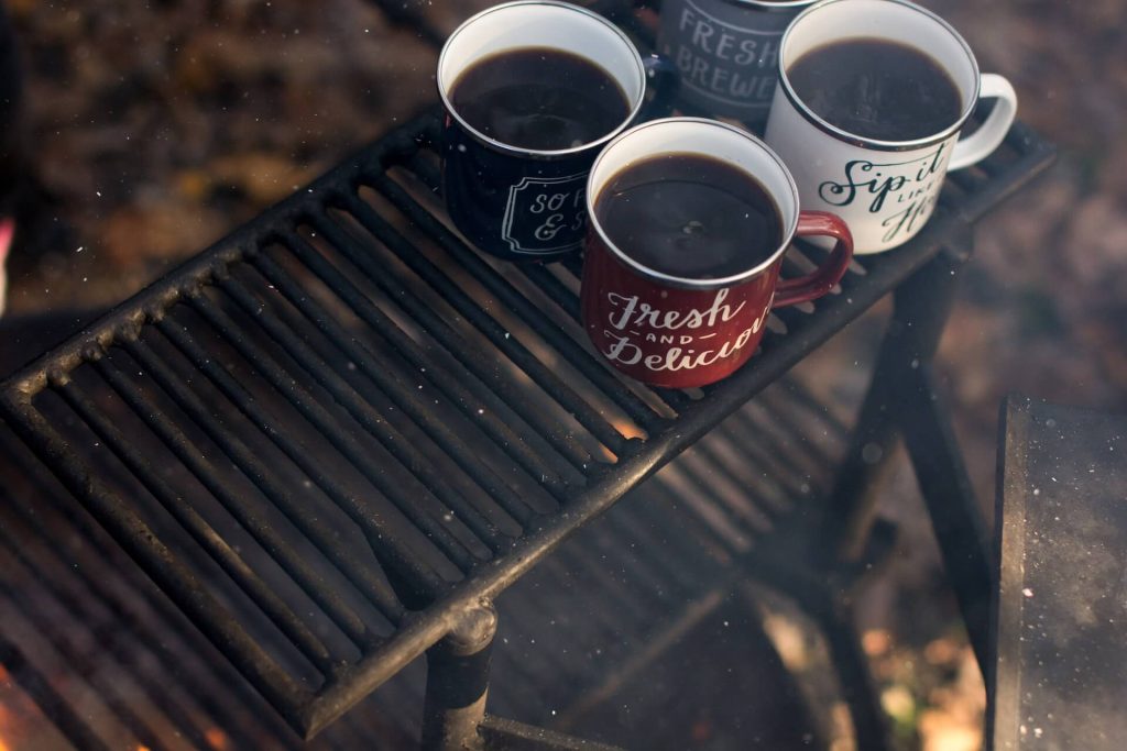 three cups of coffee over camp fire